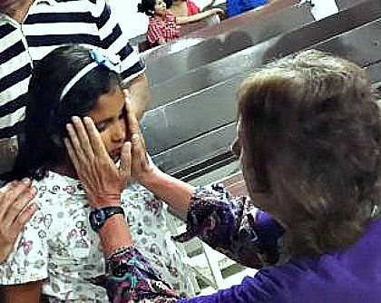 photo of a woman laying hands on a blind girl, who immediately had her sight restored